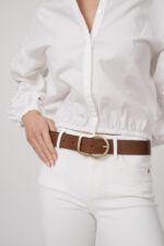 Model trägt eine weiße Jeans von True Religion. Der braue Gürtel ist von Dorothee Schumacher.