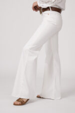 Model trägt eine weiße Jeans von True Religion. Der braue Gürtel ist von Dorothee Schumacher.