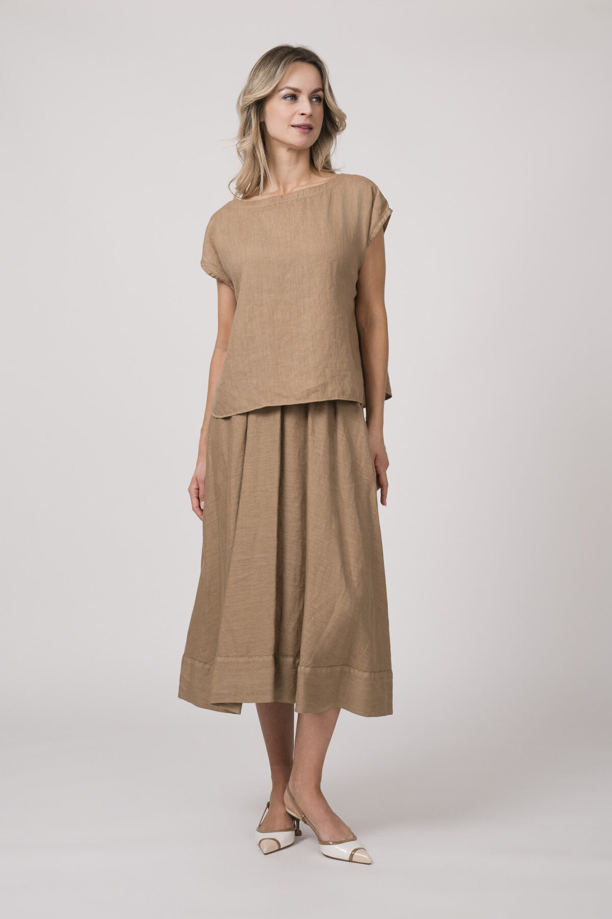 Model trägt ein beiges Outfit der Marke Rosso35 bestehend aus: Shirt und Rock