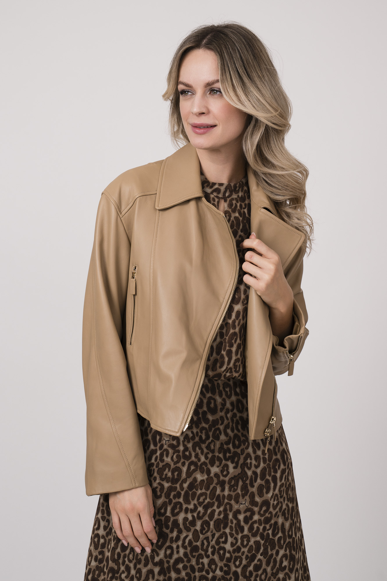 Model trägt eine beige Lederjacke der Marke Luisa Cerano und ein Kleid mit Leoprint der Marke Joop!