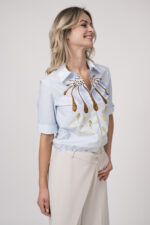 Model trägt eine hellblaue Bluse mit Blumenmuster der Marke Dorothee Schumacher.