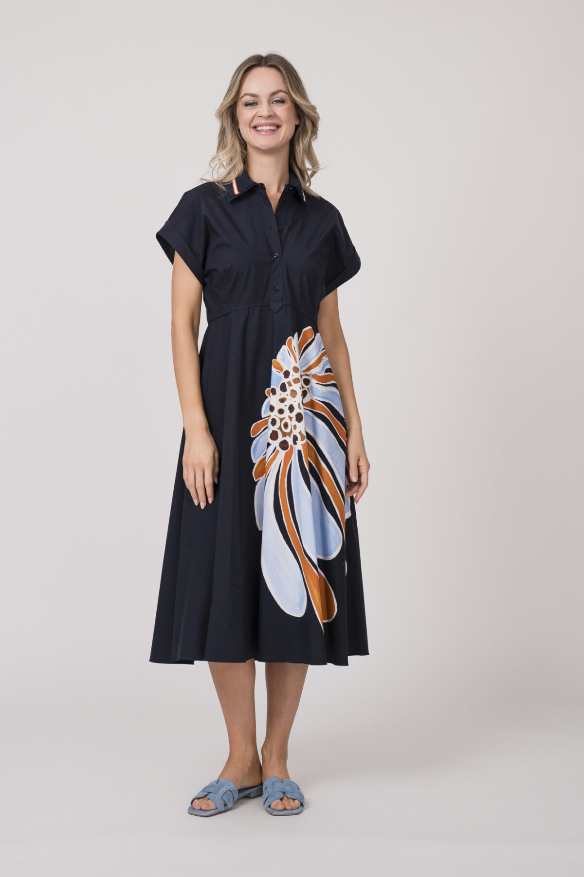 Model trägt ein dunkelblaues Kleid mit Kragen und Blumenmuster der Marke Dorothee Schumacher.