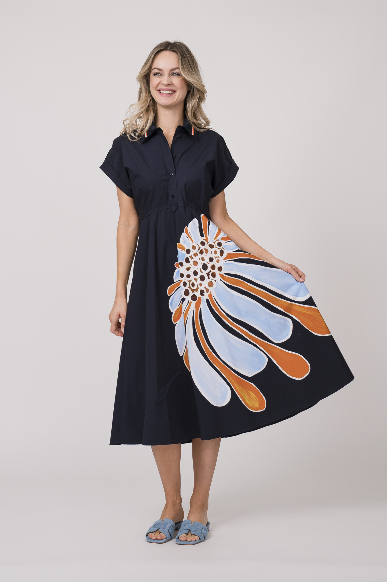 Model trägt ein dunkelblaues Kleid mit Kragen und Blumenmuster der Marke Dorothee Schumacher.