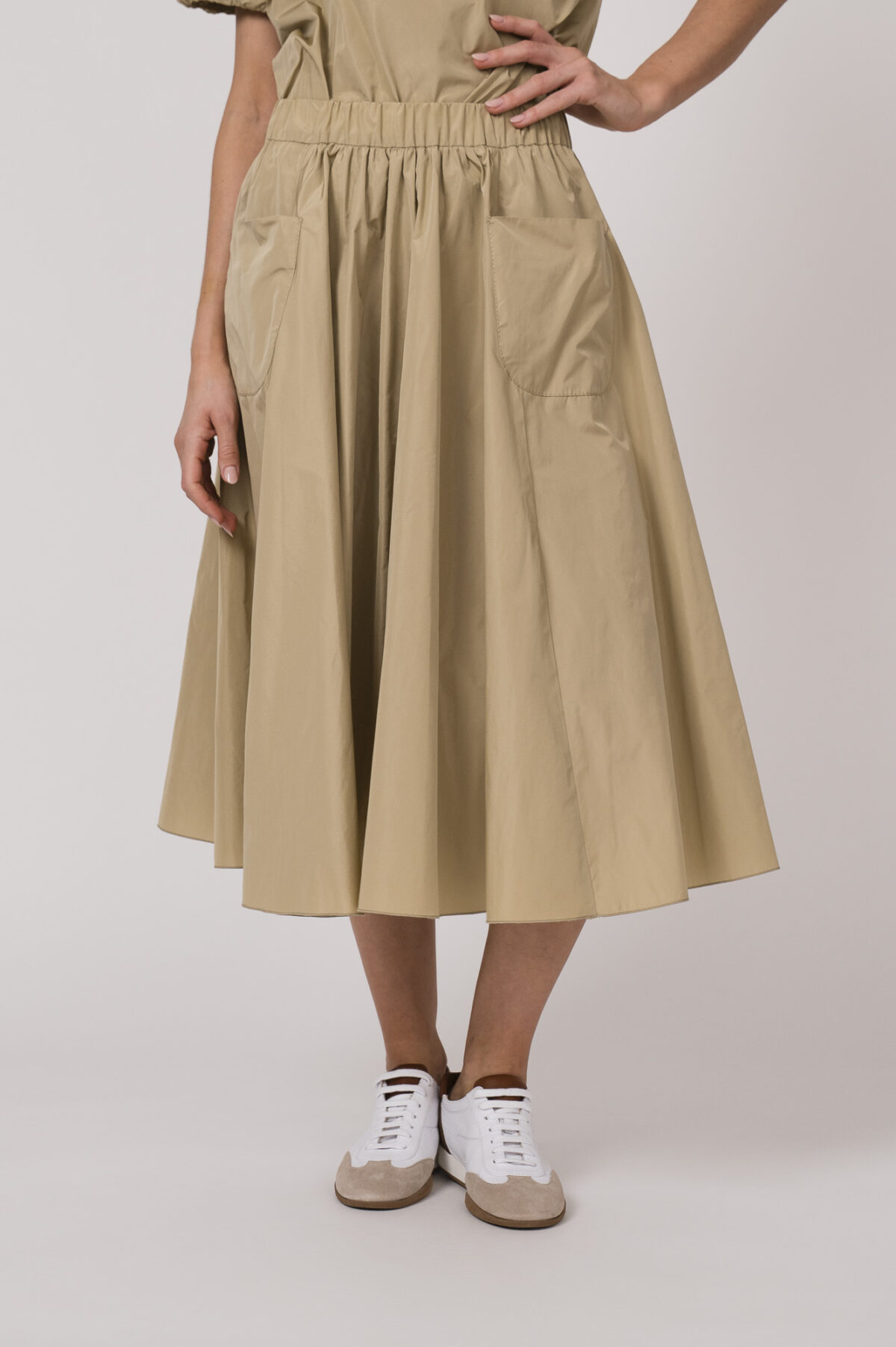 Model trägt einen beigen Rock der Marke Susanne Bommer