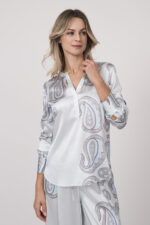 Model trägt eine fließende Bluse in hellem Blau mit Paisley Muster der Marke Herzens.