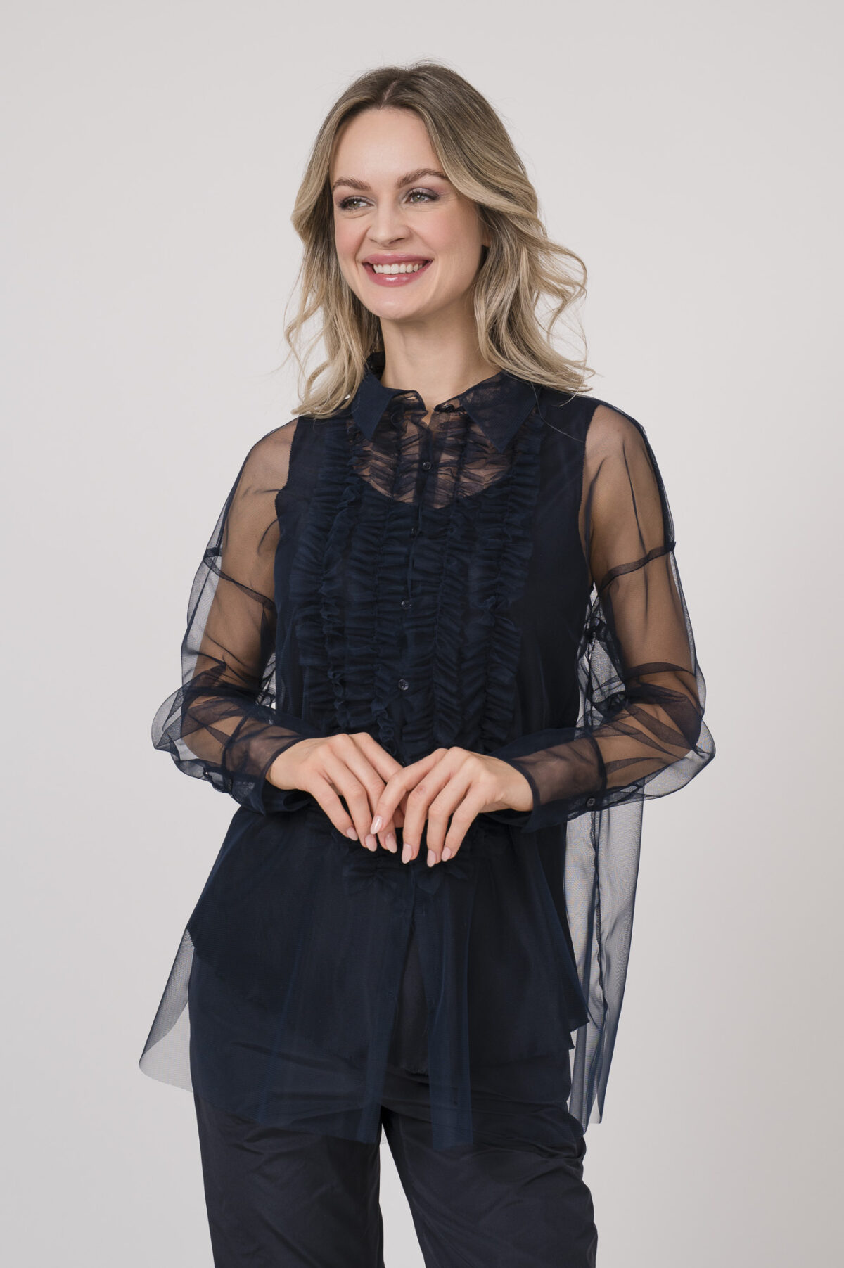 Model trägt ein Outfit der Marke Susanne Bommer in marine-blau bestehend aus: einem ärmellosem Seidentop, einer durchsichtige Tüllbluse.