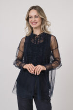 Model trägt ein Outfit der Marke Susanne Bommer in marine-blau bestehend aus: einem ärmellosem Seidentop, einer durchsichtige Tüllbluse.