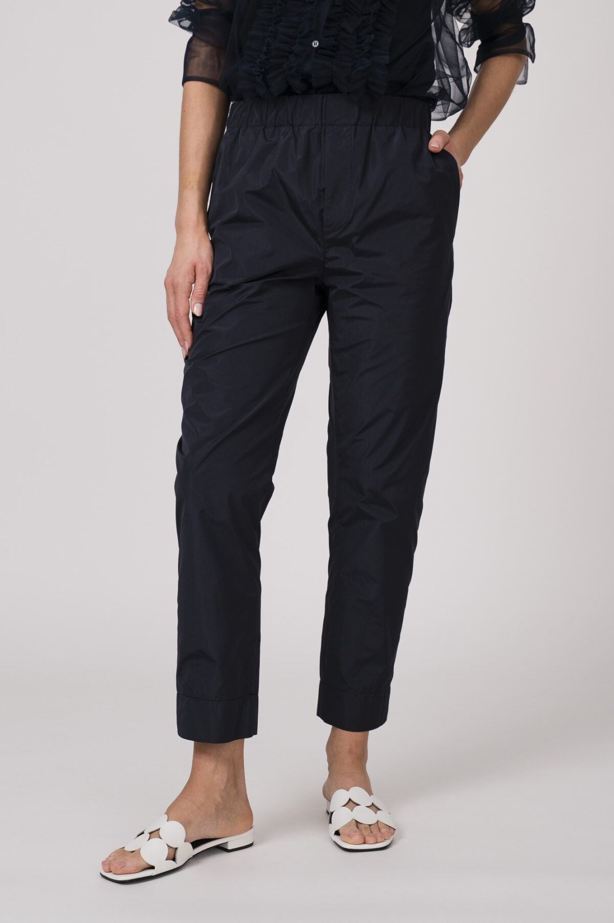 Model trägt ein Outfit der Marke Susanne Bommer in marine-blau bestehend aus einer Stoffhose