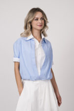 Model trägt eine doppelte Bluse in weiß und hellblau der Marke Dorothee Schumacher.