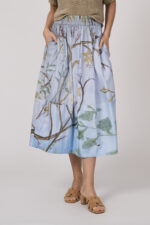 Model trägt einen hellblau gemusterten Rock der Marke Talking Walls.