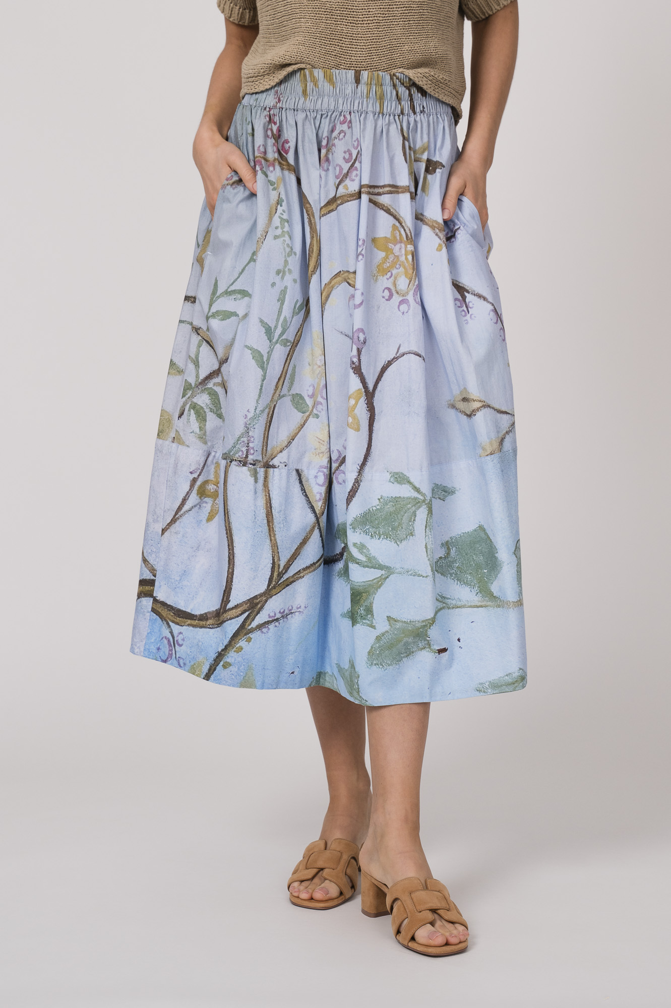 Model trägt einen hellblau gemusterten Rock der Marke Talking Walls.