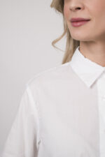 Model trägt eine weiße Bluse der Marke Rossana Diva.