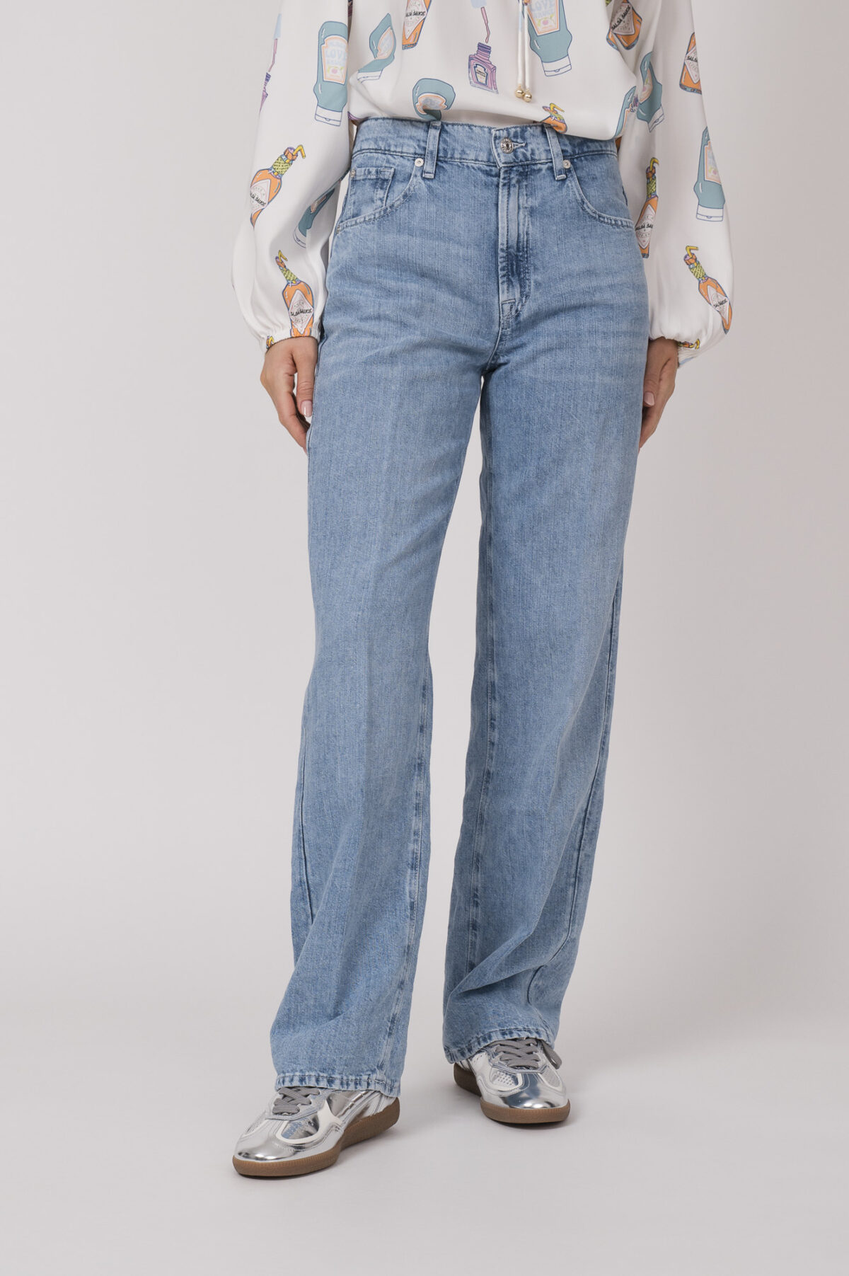 Model trägt eine hellblaue Jeans der Marke 7 for all Mankind.