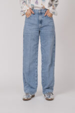 Model trägt eine hellblaue Jeans der Marke 7 for all Mankind.