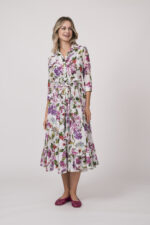 Model trägt ein helles Kleid mit floralem Muster der Marke Samantha Sung.