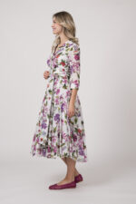 Model trägt ein helles Kleid mit floralem Muster der Marke Samantha Sung.