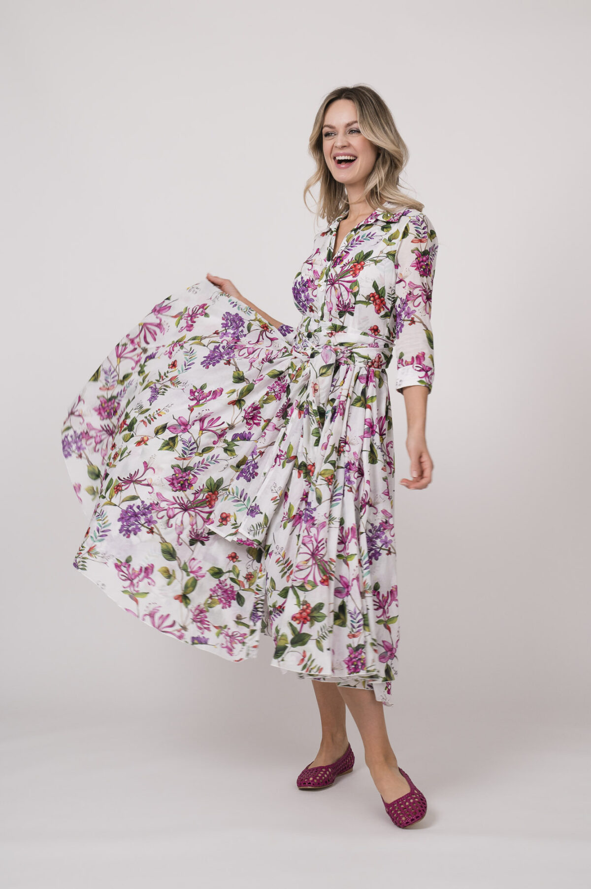 Model trägt ein helles Kleid mit floralem Muster der Marke Samantha Sung.