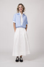 Model trägt eine doppelte Bluse in weiß und hellblau der Marke Dorothee Schumacher und einen weißen Rock der Marke Joop!
