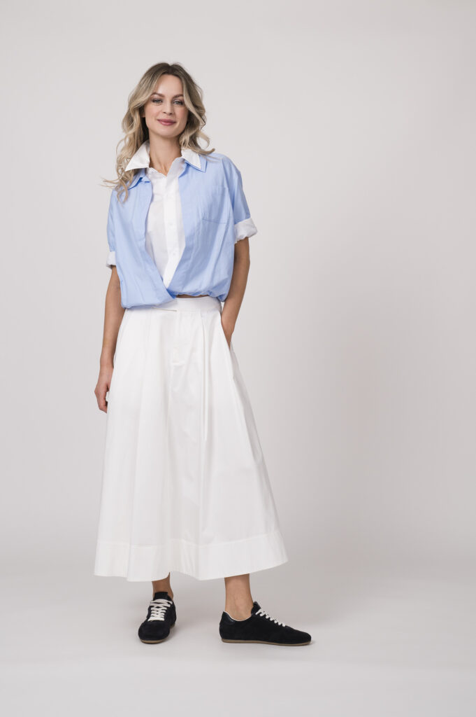 Model trägt eine doppelte Bluse in weiß und hellblau der Marke Dorothee Schumacher und einen weißen Rock der Marke Joop!