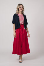 Model trägt einen dunkelblauen Kurzarm-Sweater mit Reißverschluss, ein rot-weiß gestreiftes Shirt, einen roten Rock - alles von der Marke Joop!