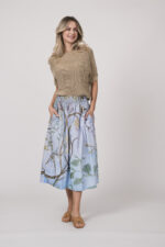 Model zeigt einen beigen Kurzarm-Pullover der Marke Talking Walls und einen hellblau gemusterten Rock der Marke Talking Walls.