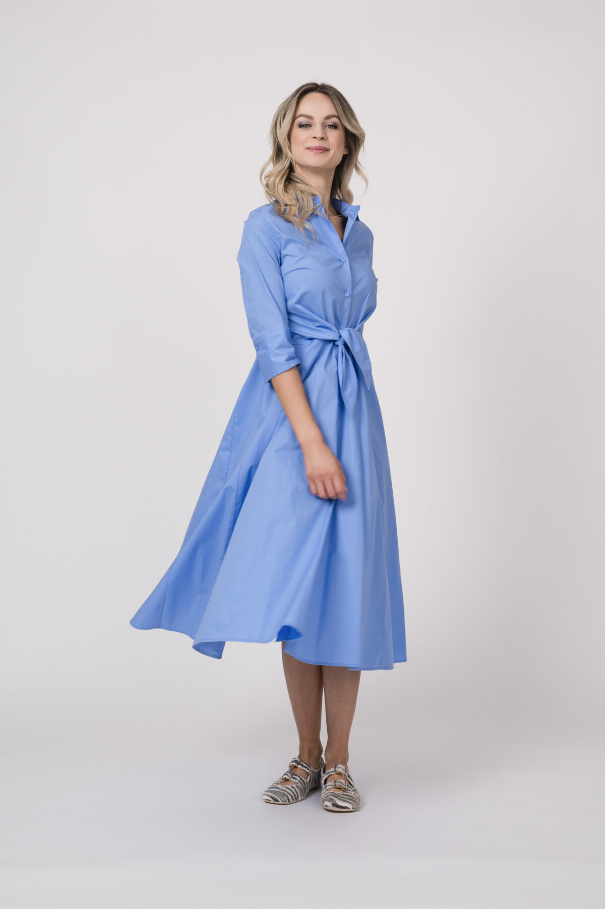 Model trägt ein langes Kleid in Blau der Marke Rosso35.