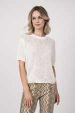 Model trägt eine gemusterte Hose der Marke Cambio, dazu einen Kurzarmpullover der Marke FFC in Weiß.