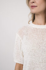 Model trägt eine gemusterte Hose der Marke Cambio, dazu einen Kurzarmpullover der Marke FFC in Weiß.