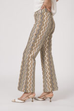 Model trägt eine gemusterte Hose der Marke Cambio, dazu einen Kurzarmpullover der Marke FFC in Weiß.