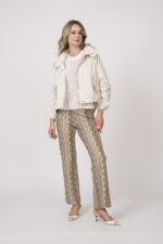 Model trägt eine Jacke der Marke Mabrun in Natur mit goldfarbenen Druckknöpfen. Dazu trägt sie eine gemusterte Hose der Marke Cambio und einen Kurzarmpullover der Marke FFC in Weiß.