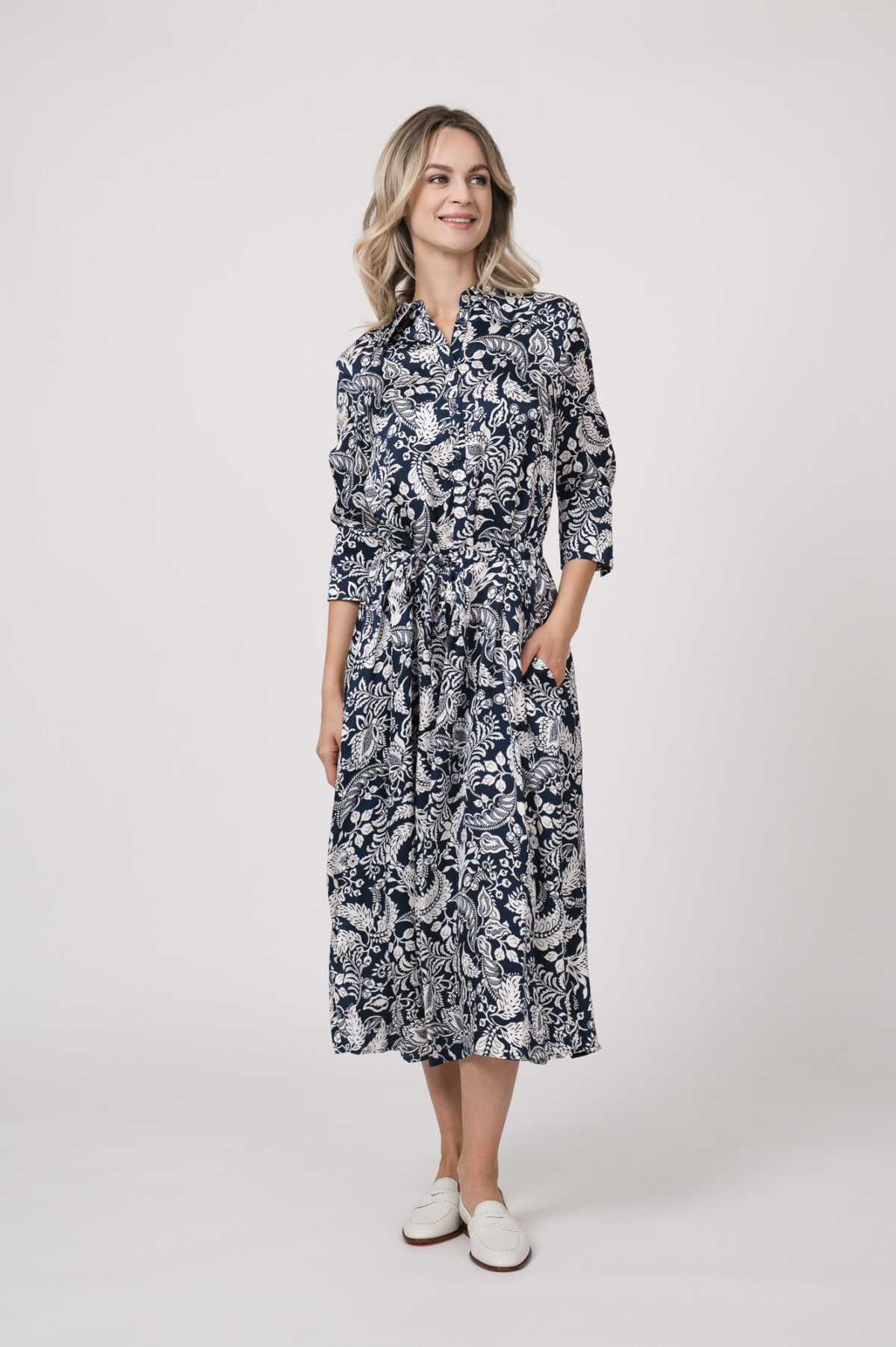 Model trägt ein langes Kleid der Marke Joop! mit blau-weißem Muster.