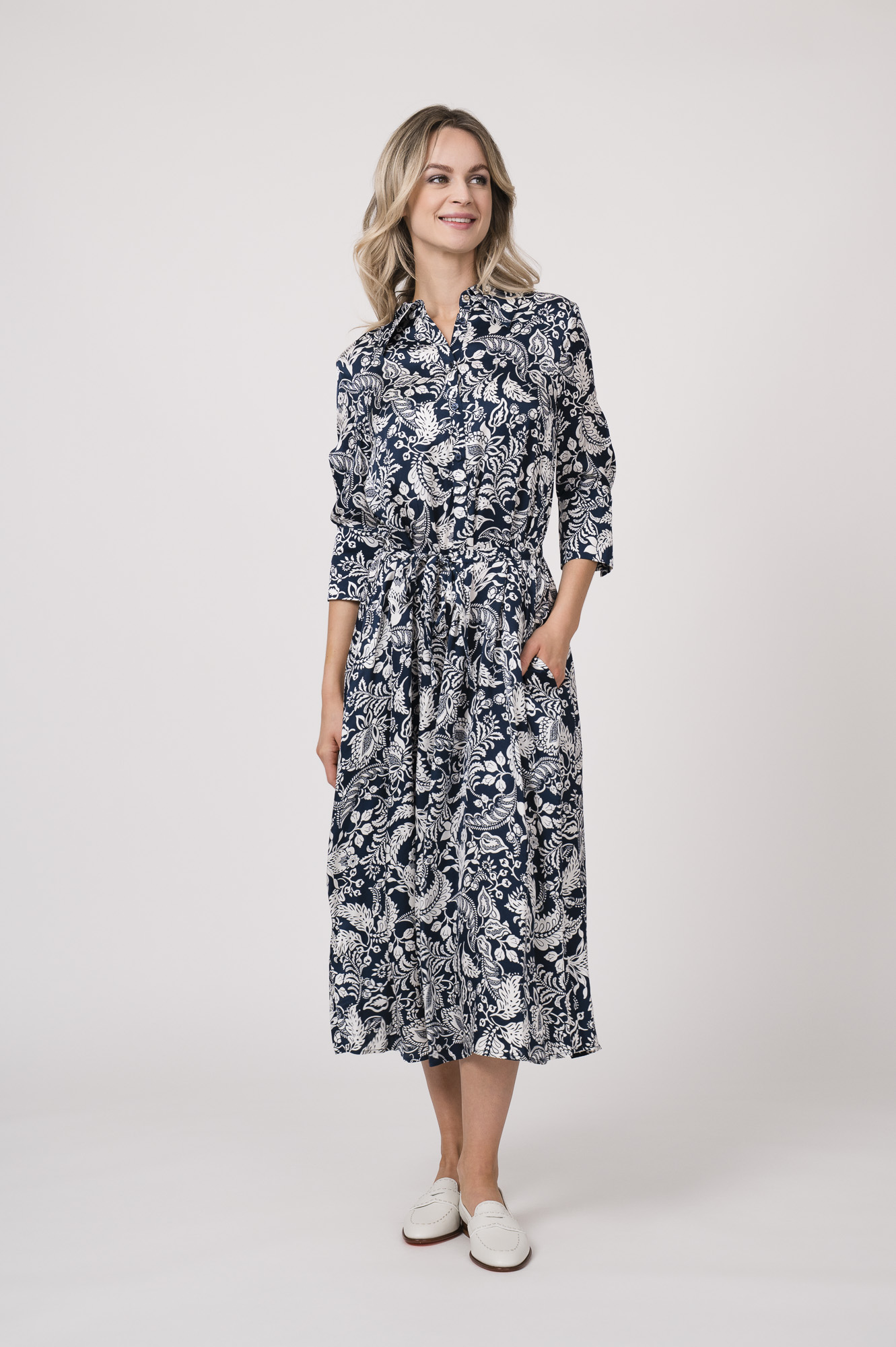 Model trägt ein langes Kleid der Marke Joop! mit blau-weißem Muster.