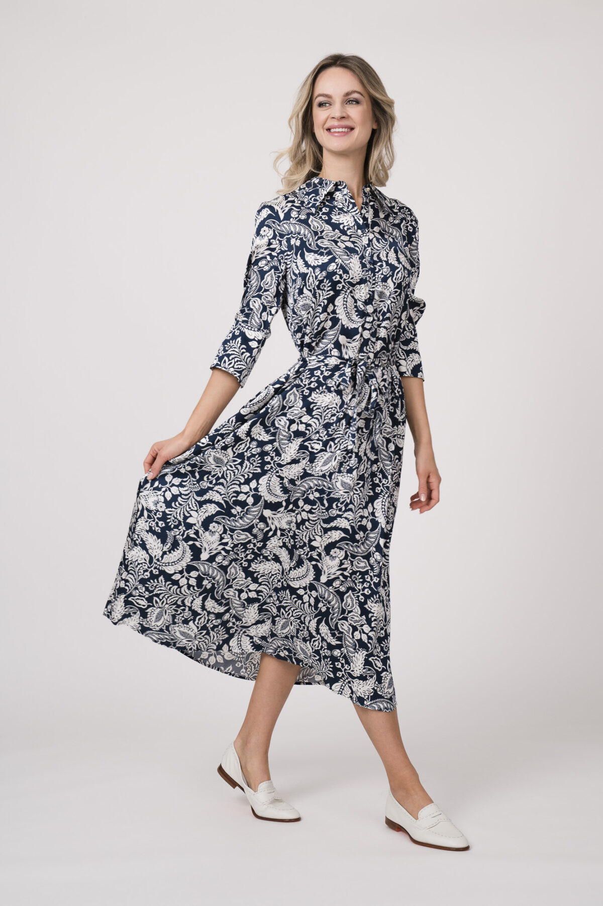 Model trägt ein langes Kleid der Marke Joop! mit blau-weißem Muster.