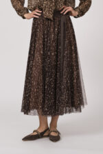 Model trägt eine Bluse mit Schnuppe der Marke Joop! und einen dazu passenden Plisseerock der Marke Joop!. Beides in einem Leo-Muster.