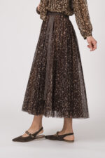 Model trägt eine Bluse mit Schnuppe der Marke Joop! und einen dazu passenden Plisseerock der Marke Joop!. Beides in einem Leo-Muster.