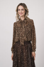 Model trägt eine Bluse mit Schnuppe der Marke Joop! und einen dazu passenden Plisseerock der Marke Joop!. Beides in einem Leo-Muster.