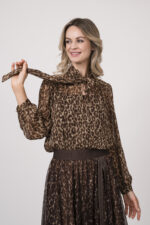 Model trägt eine Bluse mit Schnuppe der Marke Joop! und einen dazu passenden Plisseerock der Marke Joop!. Beides in einem Leo-Muster.