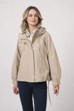 Model trägt eine Jacke der Marke Duno in der Farbe Sand. Eine Bluse der Marke Rossana Diva mit Blumenmuster. Dazu eine Hose der Marke Mason's in Marine.