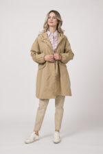 Model trägt einen Mantel der Marke Mabrun in der Farbe Camel. Eine Bluse der Marke Rossana Diva mit Blumenmuster. Dazu eine Hose der Marke Mason's in der Farbe Sand.