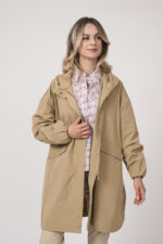 Model trägt einen Mantel der Marke Mabrun in der Farbe Camel. Eine Bluse der Marke Rossana Diva mit Blumenmuster. Dazu eine Hose der Marke Mason's in der Farbe Sand.