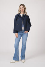 Model trägt einen blau-weiß gestreiften Pullover der Marke Dorothee Schumacher, dazu eine Jeans der Marke Closed in hellblau und eine Jacke der Marke Cinzia Rocca in Marine.