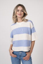 Model trägt einen blau-weiß gestreiften Pullover der Marke Dorothee Schumacher, dazu eine Jeans der Marke Closed in hellblau.