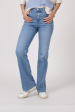 Model trägt einen blau-weiß gestreiften Pullover der Marke Dorothee Schumacher, dazu eine Jeans der Marke Closed in hellblau.