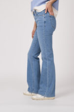 Model trägt einen blau-weiß gestreiften Pullover der Marke Dorothee Schumacher, dazu eine Jeans der Marke Closed in hellblau.