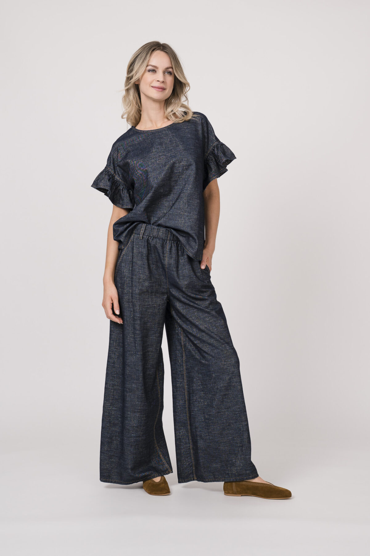 Model trägt ein denim Kurzarmshirt der Marke Susanne Bommer, dazu die passenden Jeans der Marke Susanne Bommer.