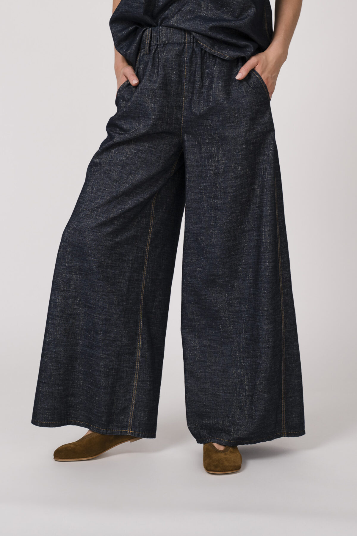 Model trägt ein denim Kurzarmshirt der Marke Susanne Bommer, dazu die passenden Jeans der Marke Susanne Bommer.