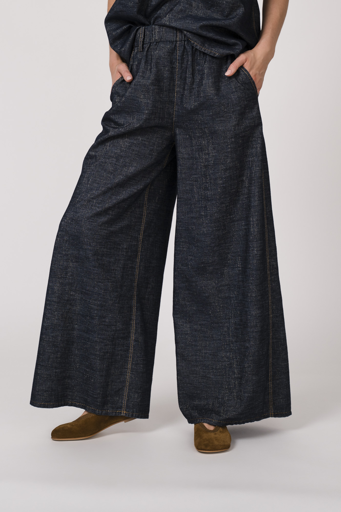 Model trägt ein denim Kurzarmshirt der Marke Susanne Bommer, dazu die passenden Jeans der Marke Susanne Bommer.