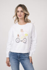 Model trägt einen Lounge-Sweater der Marke Sustyle in Weiß mit Motiv in Pink auf der Vorderseite. Dazu eine Jeans der Marke True Religion in Mittelblau.