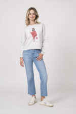 Model trägt einen Lounge-Sweater der Marke Sustyle in Hellgrau mit Motiv auf der Vorderseite. Dazu eine Jeans der Marke 7 for all mankind in Mittelblau.