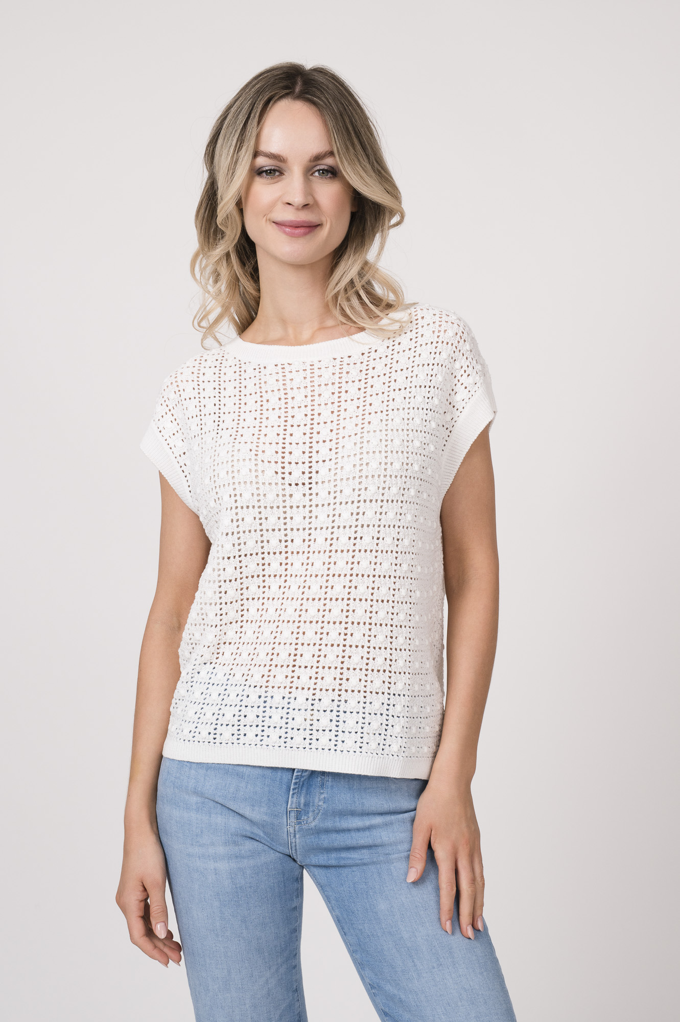 Model trägt einen Kurzarmpulli der Marke Joop! in Weiß, eine Jeans der Marke 7 for all mankind in hellblau.